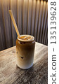 Iced latte coffee in glass jar on wooden table in cafe 135139628