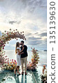Romantic couple kissing under floral wedding arch by the sea 135139630