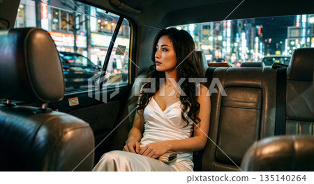 一名女子坐在計程車後座。 135140264
