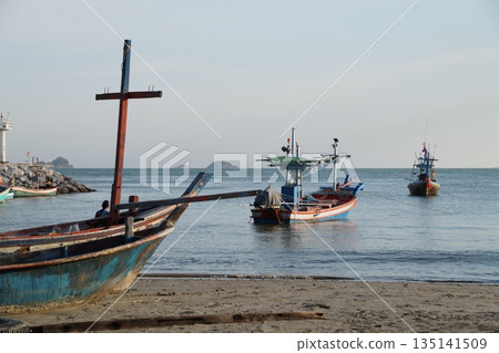Fishing boats in the sea. Several wooden, colorful fishing boats are standing in the sea near the shore. Fishing boats in the sea. Several wooden, colorful fishing boats are standing in the sea near the shore. 135141509