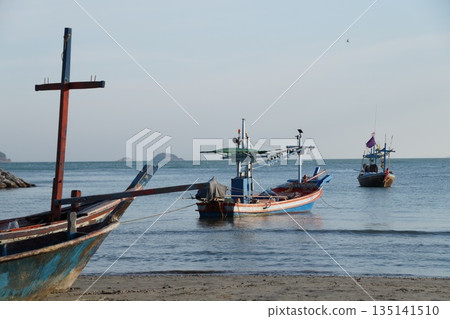 Fishing boats at sea.Fishing boats in the sea. Several wooden, colorful fishing boats are standing in the sea near the shore. 135141510