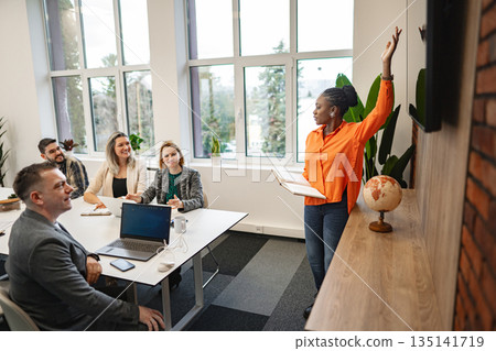 Group of People Sitting Around a Table With Laptops 135141719