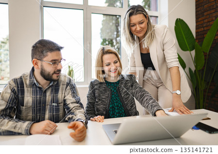 Group of People Sitting Around a Table With a Laptop Group of People Sitting Around a Table With a Laptop 135141721