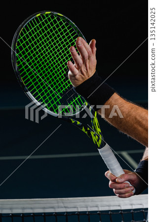 Tennis racket and hand touching strings near net Tennis racket and hand touching strings near net 135142025