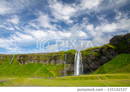 塞里雅蘭瀑布 (Seljalandsfoss) 從塞里雅蘭河 (Seljalandssá River) 傾瀉而下，映襯著冰島蔚藍天空中的層層疊疊的雲朵。 135142537