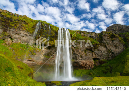 塞里雅蘭瀑布 (Seljalandsfoss) 從塞里雅蘭河 (Seljalandssá River) 傾瀉而下，映襯著冰島蔚藍天空中的層層疊疊的雲朵。 135142540