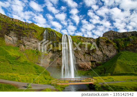 塞里雅蘭瀑布 (Seljalandsfoss) 從塞里雅蘭河 (Seljalandssá River) 傾瀉而下,映襯著冰島蔚藍天空中的層層疊疊的雲朵。 塞里雅蘭瀑布 (Seljalandsfoss) 從塞里雅蘭河 (Seljalandssá River) 傾瀉而下,映襯著冰島蔚藍天空中的層層疊疊的雲朵。 135142542