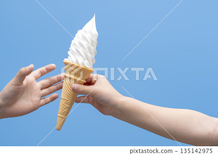 A summer scene of a child handing over a soft serve ice cream 135142975