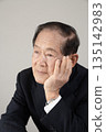 Bust enhancement of a senior man resting his chin on his hand 135142983