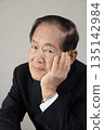Bust enhancement of a senior man resting his chin on his hand 135142984
