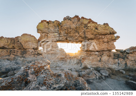 Isalo Madagascar. Golden sunburst through a natural rock arch at sunset Isalo Madagascar. Golden sunburst through a natural rock arch at sunset 135142989