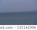 A view of the blue sky, the rippling sea, and the land on the opposite shore A view of the blue sky, the rippling sea, and the land on the opposite shore 135142996