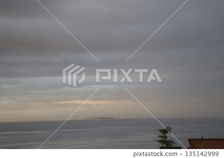Seascape of cloudy sunrise sky, island and sea surface Seascape of cloudy sunrise sky, island and sea surface 135142999