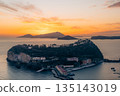 Coastal town buildings at sunset with mountains in the background. Nisida, Naples 135143019