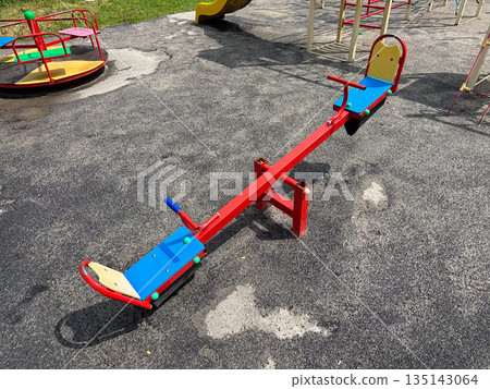 Empty seesaw on a playground under a clear sky. Empty seesaw on a playground under a clear sky. 135143064
