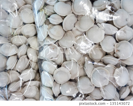 Packaged frozen dumplings in clear plastic bags. Packaged frozen dumplings in clear plastic bags. 135143072