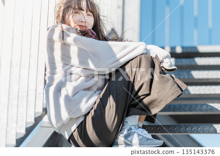 Women sitting on the stairs 135143376