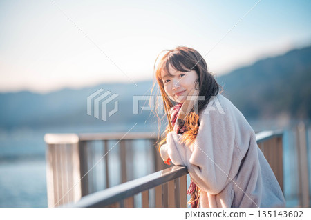 年輕女子站在海灘上 年輕女子站在海灘上 135143602