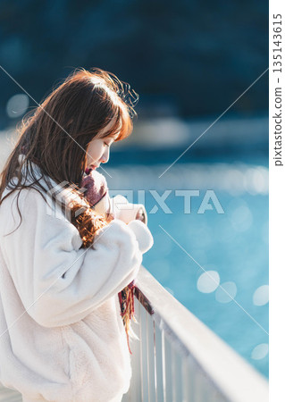 年輕女子站在海灘上 年輕女子站在海灘上 135143615