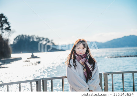 年輕女子站在海灘上 年輕女子站在海灘上 135143624