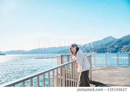young woman standing on the beach young woman standing on the beach 135143627
