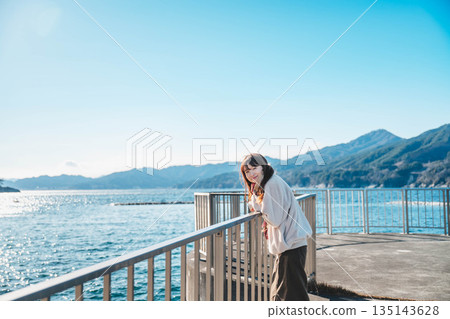 年輕女子站在海灘上 年輕女子站在海灘上 135143628