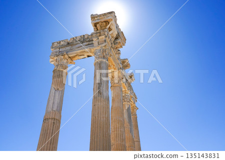 Majestic Ancient Pillars Bathed in Bright Sunlight Against a Clear Blue Sky, Highlighting Historical Architectural Grandeur Majestic Ancient Pillars Bathed in Bright Sunlight Against a Clear Blue Sky, Highlighting Historical Architectural Grandeur 135143831