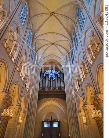 Paris, France - December 10, 2025:The grand organ under a vibrant rose window inside the stunning Notre-Dame Cathedral. Soaring vaulted ceiling and intricate stained glass bathe the stone architecture Paris, France - December 10, 2025:The grand organ under a vibrant rose window inside the stunning Notre-Dame Cathedral. Soaring vaulted ceiling and intricate stained glass bathe the stone architecture 135143893