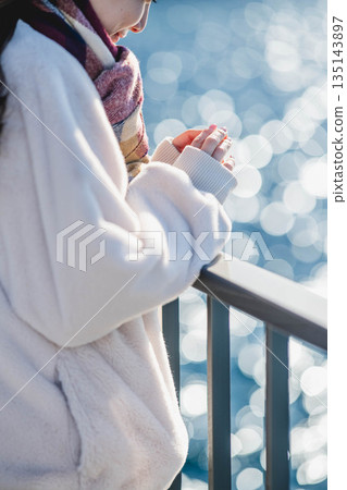 Hands of a woman standing on the beach 135143897