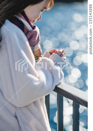 一位女子的雙手站在海灘上 135143898