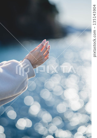 Hands of a woman standing on the beach Hands of a woman standing on the beach 135143904