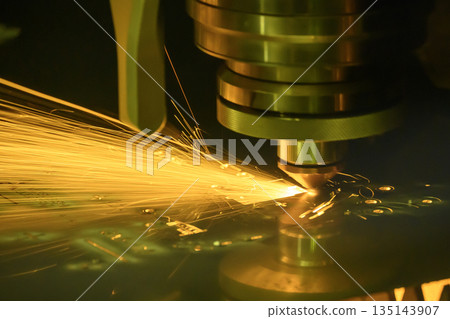 Close up scene the fiber laser cutting machine cut the metal plate control by CNC program. 135143907