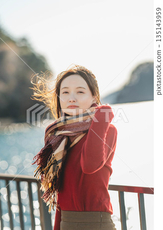 A woman looking at the scenery at the seaside in winter 135143959
