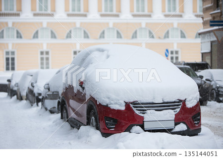 Cars covered in a thick layer of snow. Street of city after the biggest snow storm. Winter in Europe Cars covered in a thick layer of snow. Street of city after the biggest snow storm. Winter in Europe 135144051