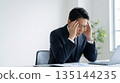 A businessman in a suit holding his head in front of a computer 16:9 Worry Fatigue Stress Manager 135144235