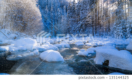 Peaceful winter river flowing through a snow covered forest during gentle snowfall. Soft sunlight reflects on icy water, creating a calm, atmospheric, and serene winter nature scene. Peaceful winter river flowing through a snow covered forest during gentle snowfall. Soft sunlight reflects on icy water, creating a calm, atmospheric, and serene winter nature scene. 135144325