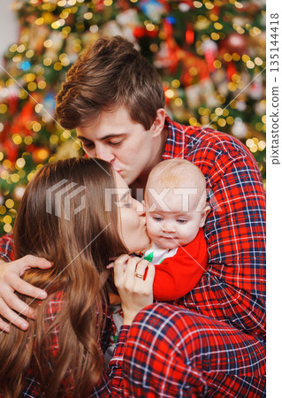 Family celebrates holiday together in front of tree Family celebrates holiday together in front of tree 135144418
