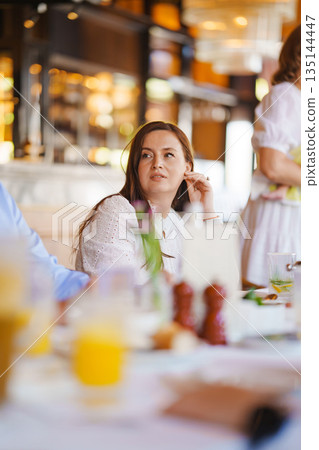Woman dining casually at a restaurant Woman dining casually at a restaurant 135144447
