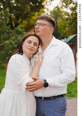 Couple embracing in a park during golden hour Couple embracing in a park during golden hour 135144448