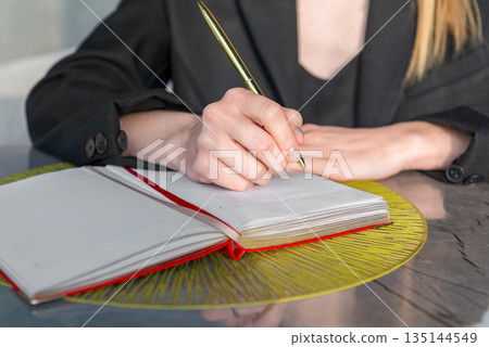 Close-up of a hands holding a pen and a notebook. Close-up of a hands holding a pen and a notebook. 135144549