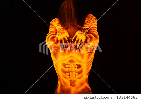 Fluorescent paint on a female back and hands. Fluorescent paint on a female back and hands. 135144562