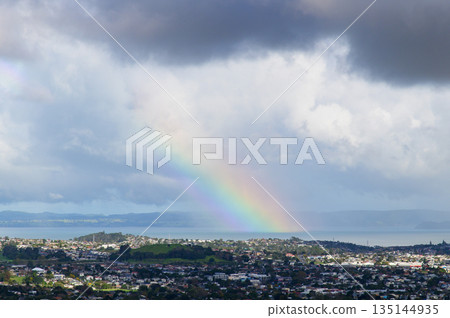 一道美麗的彩虹透過雨雲隱約可見。 135144935
