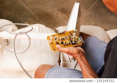 Hand of eletrician man holding electronic circuit board for repairing. Hand of eletrician man holding electronic circuit board for repairing. 135145152