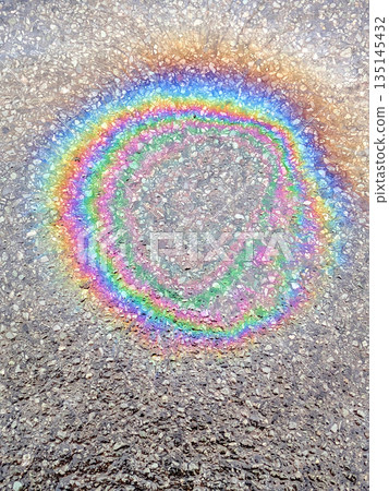 Oil Petrol Rainbow Leak Running over the road tarmac 135145432