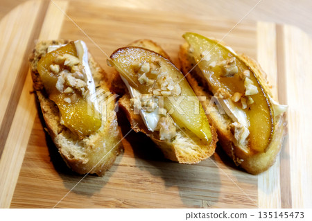 Pear bruschetta with white cheese and walnuts Pear bruschetta with white cheese and walnuts 135145473