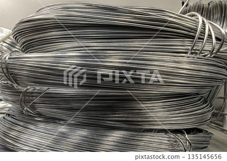 Metal wire coils arranged neatly in a storage area for various uses 135145656