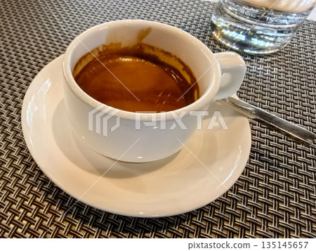 Enjoying a rich espresso in a cozy cafe setting 135145657