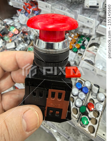 Bright red emergency stop button in a hardware store display Bright red emergency stop button in a hardware store display 135145660