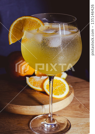 Fresh gin and tonic with ice and an orange slice , sparkling bubbles and condensation 135146426