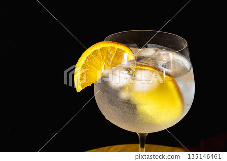 Refreshing gin tonic cocktail in a stemmed glass. Copy space.Black background 135146461